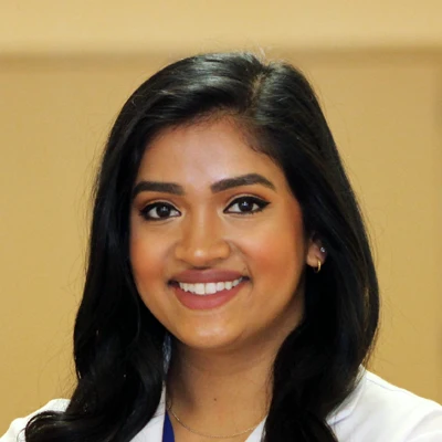 Pediatric Dentist Aneesha Amarnath Smiling While Wearing Lab Coat